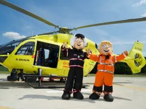 Yorkshire Air Ambulance mascots stood in front of helictoper