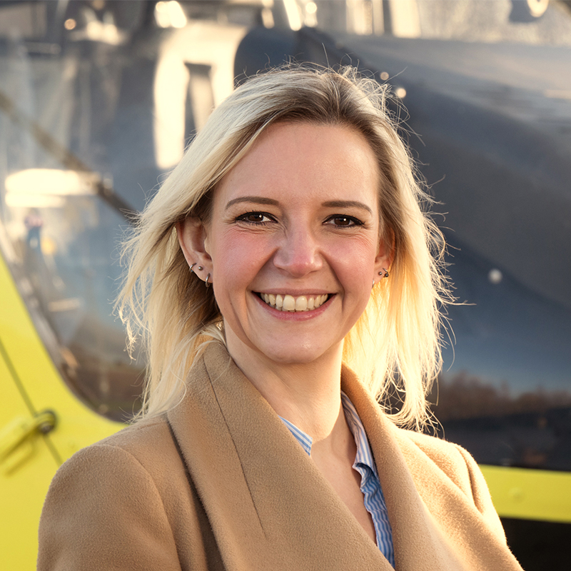 Photo of Yorkshire Air Ambulance HR Manager Laura Wilson stood in front of one of the air ambulance helicopters.