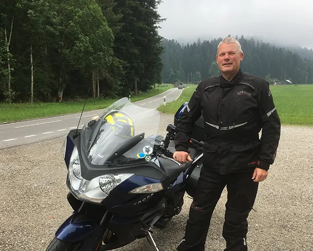 Photo of Nigel Atkinson stood next to his motorbike