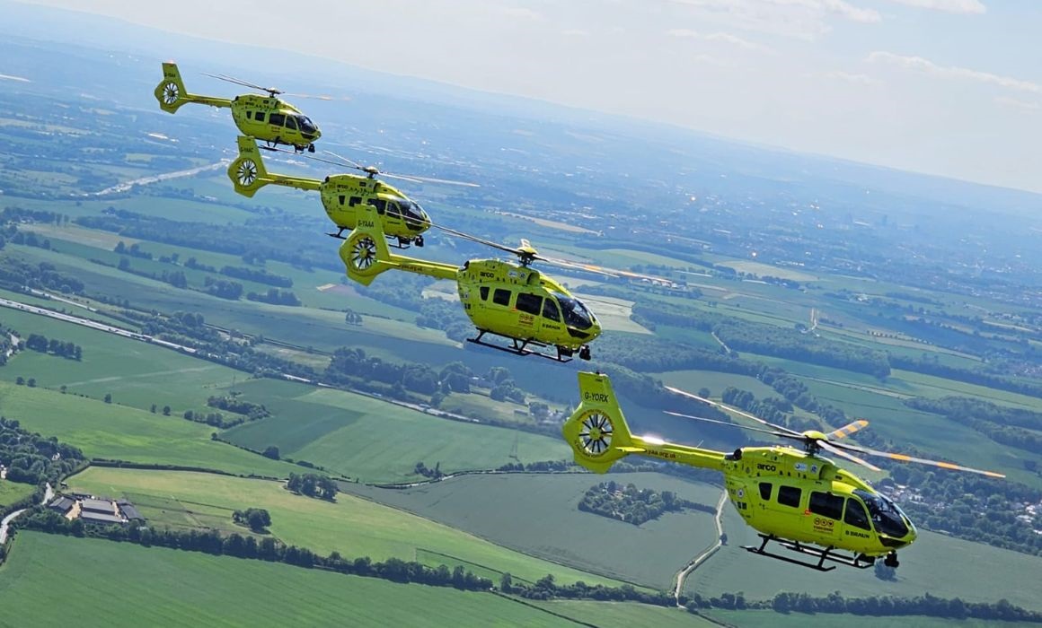 Four helicopters flying in a line