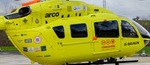 A yellow aircraft displaying various company logos.