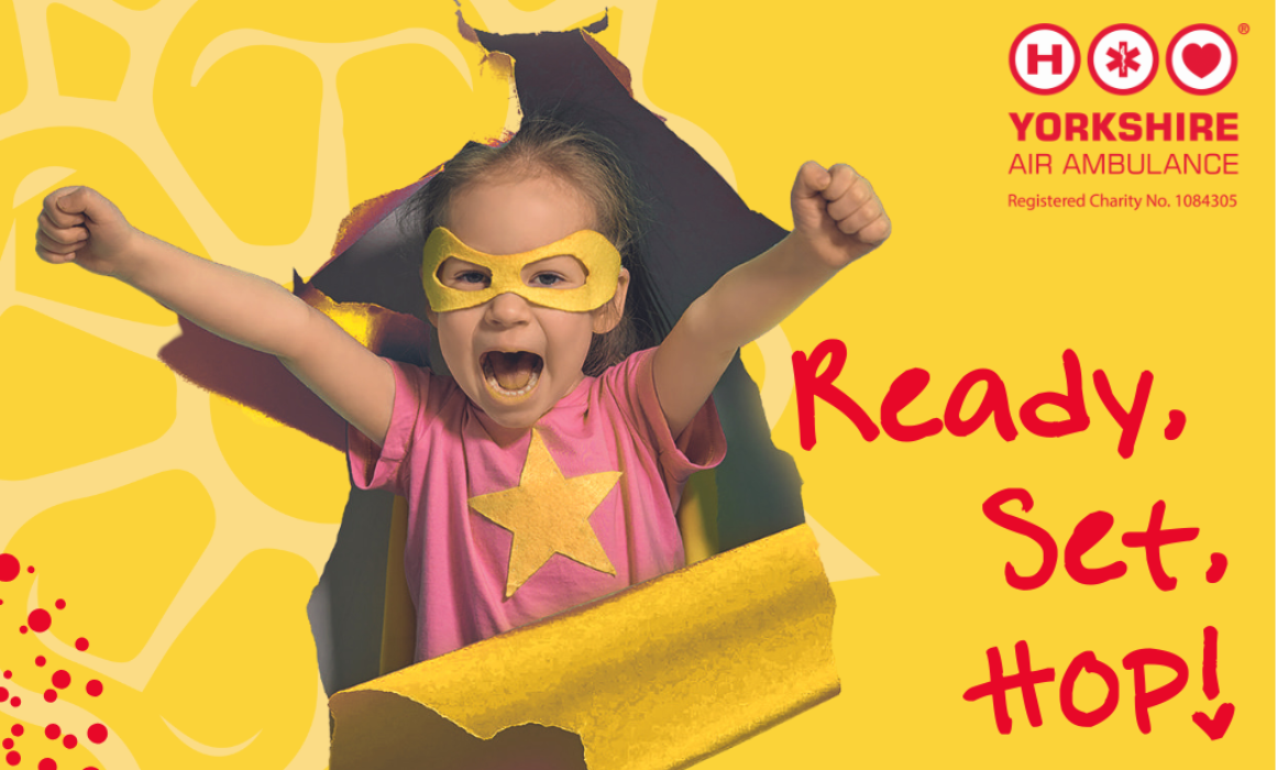 HeliHop – Web Event Image A child wearing a yellow 'hero' type eye mask and a pink t-shirt with a yellow start on, is bursting through a tear in a yellow paper with their arms in the air with clenched fists. The words 'Ready, Set, Hop!' are on the right hand side and a Yorkshire Air Ambulance Logo.