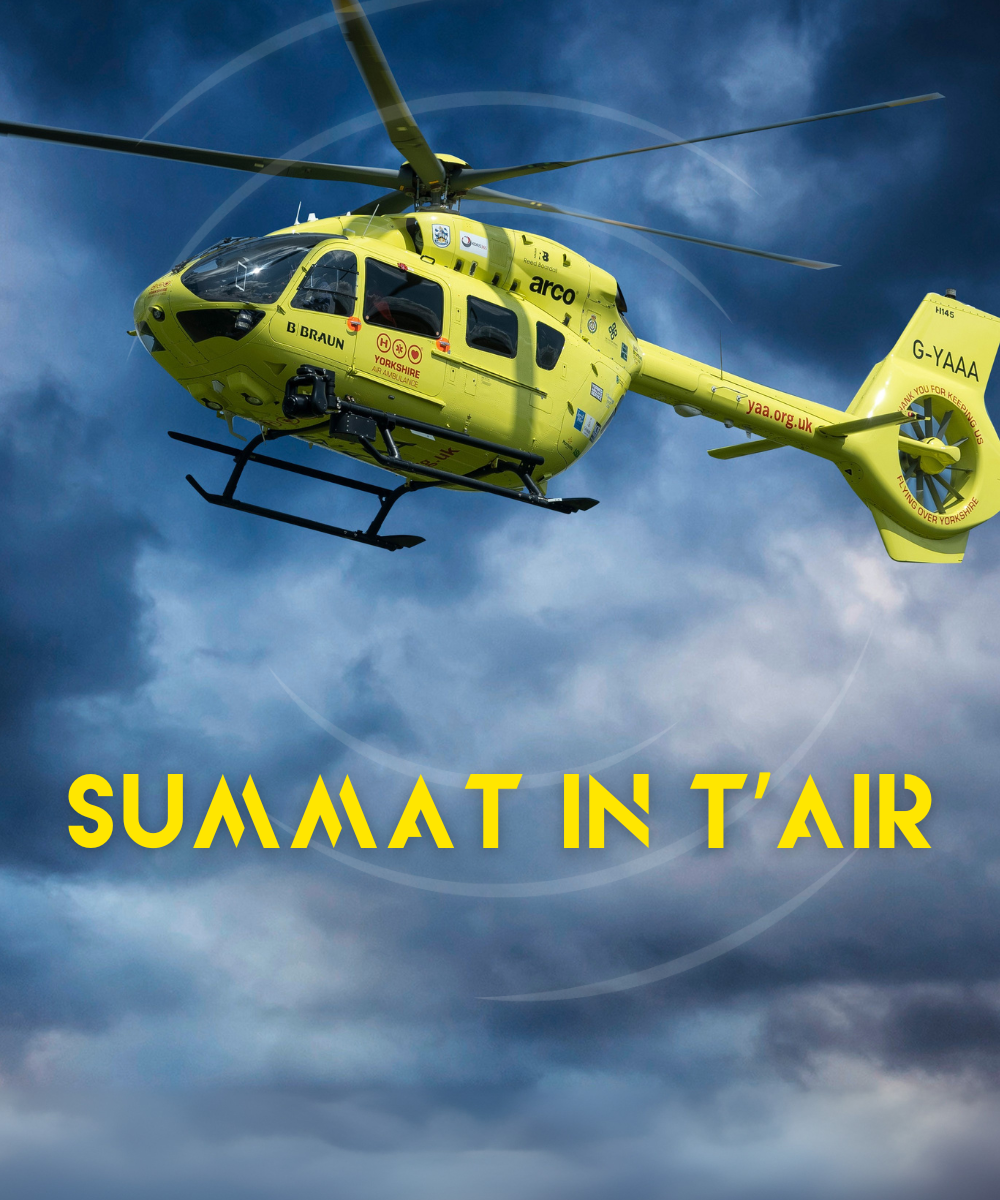 A yellow helicopter against a dark moody cloudy sky. The words 'SUMMAT IN T'AIR' in yellow.