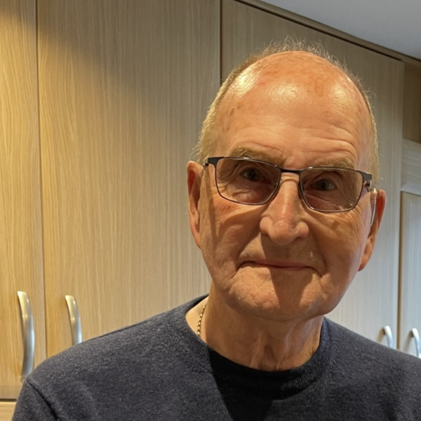 A man wearing glasses and a dark jumper