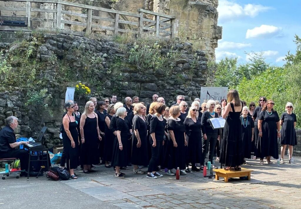 Stray Notes Events - 4th July A group of singers performing outside a castle